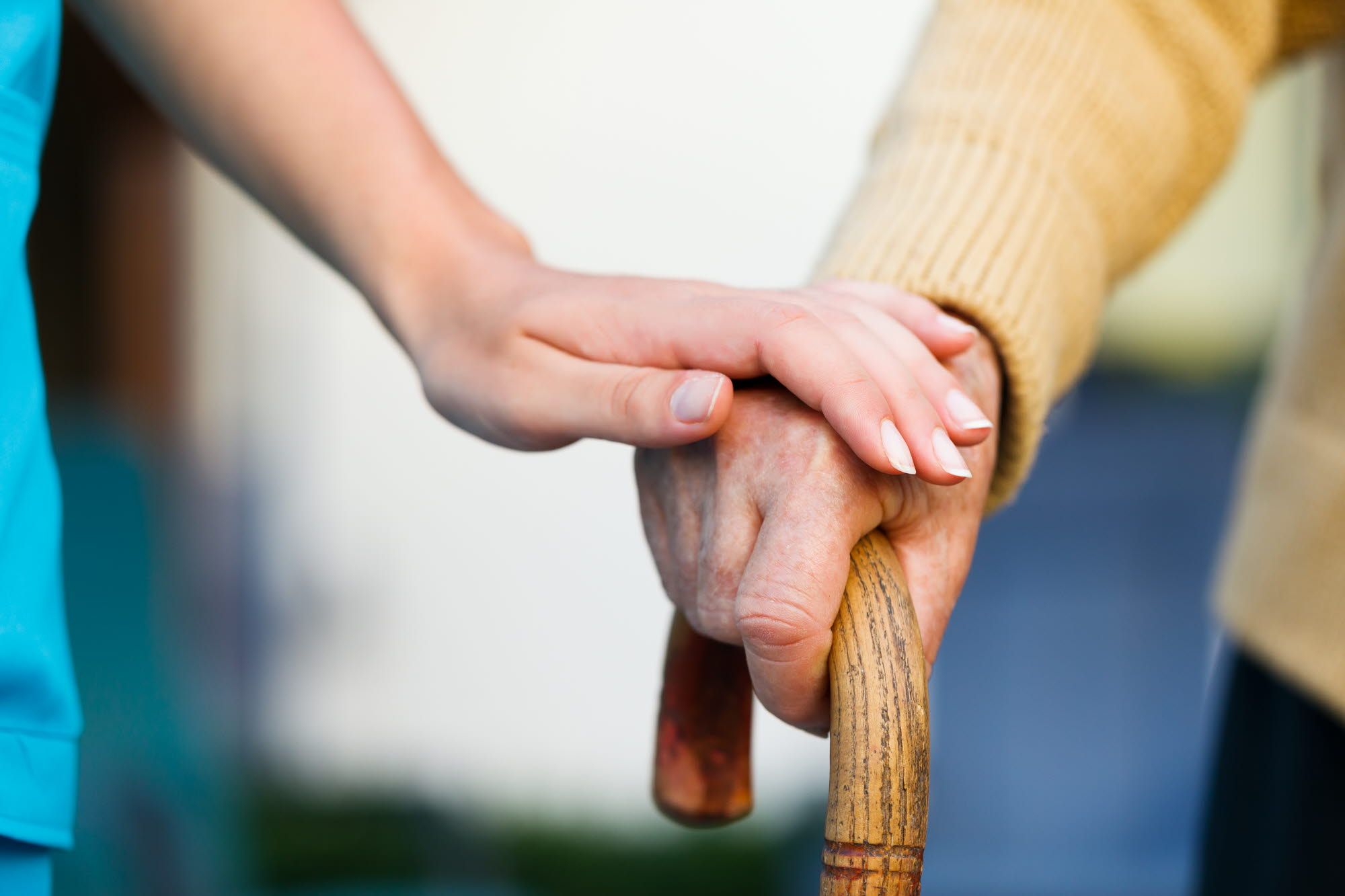 Women holding an older person's hand