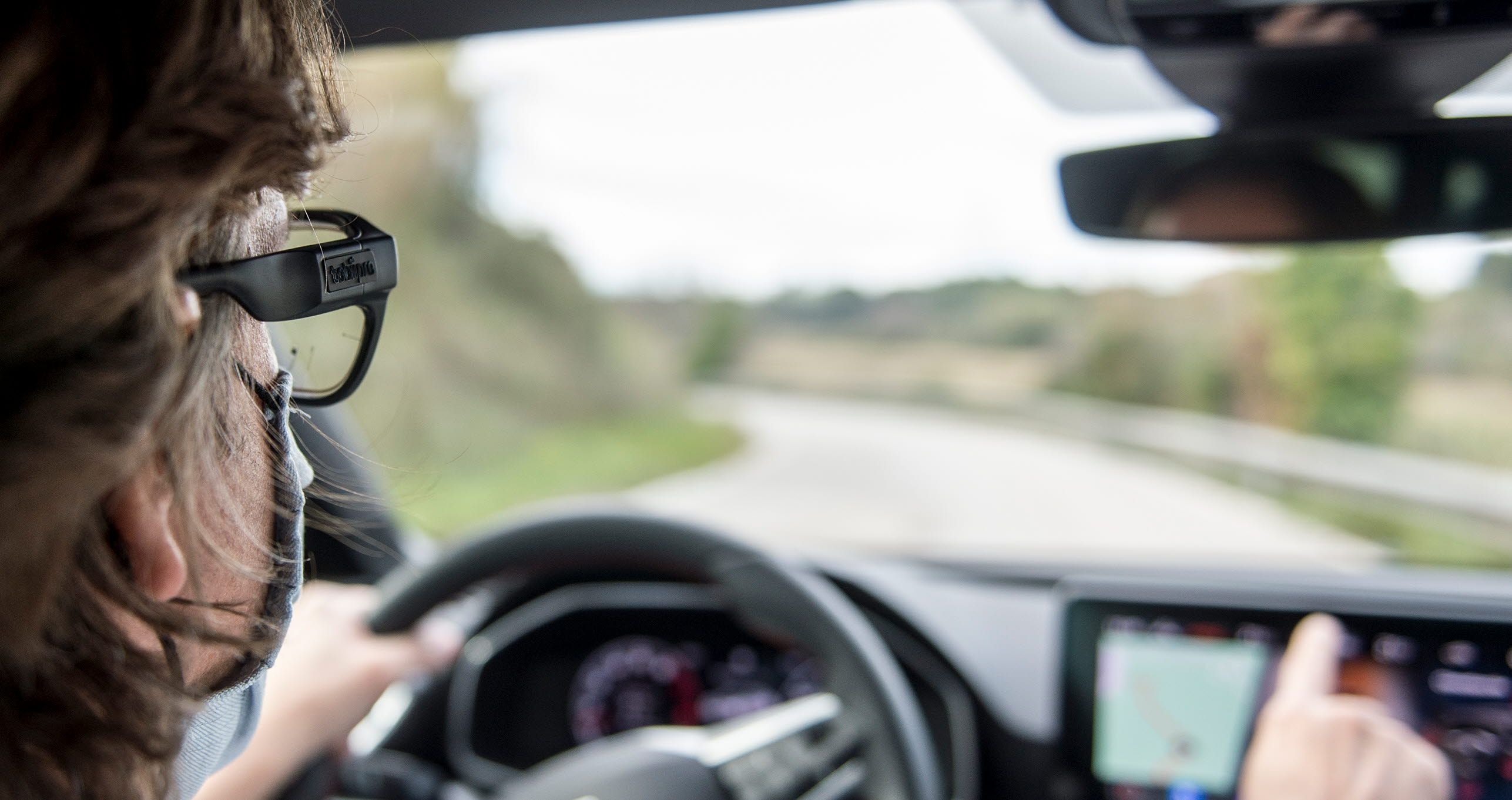 A man driving a car while wearable Tobii Pro Glasses 3 wearable eye trackers