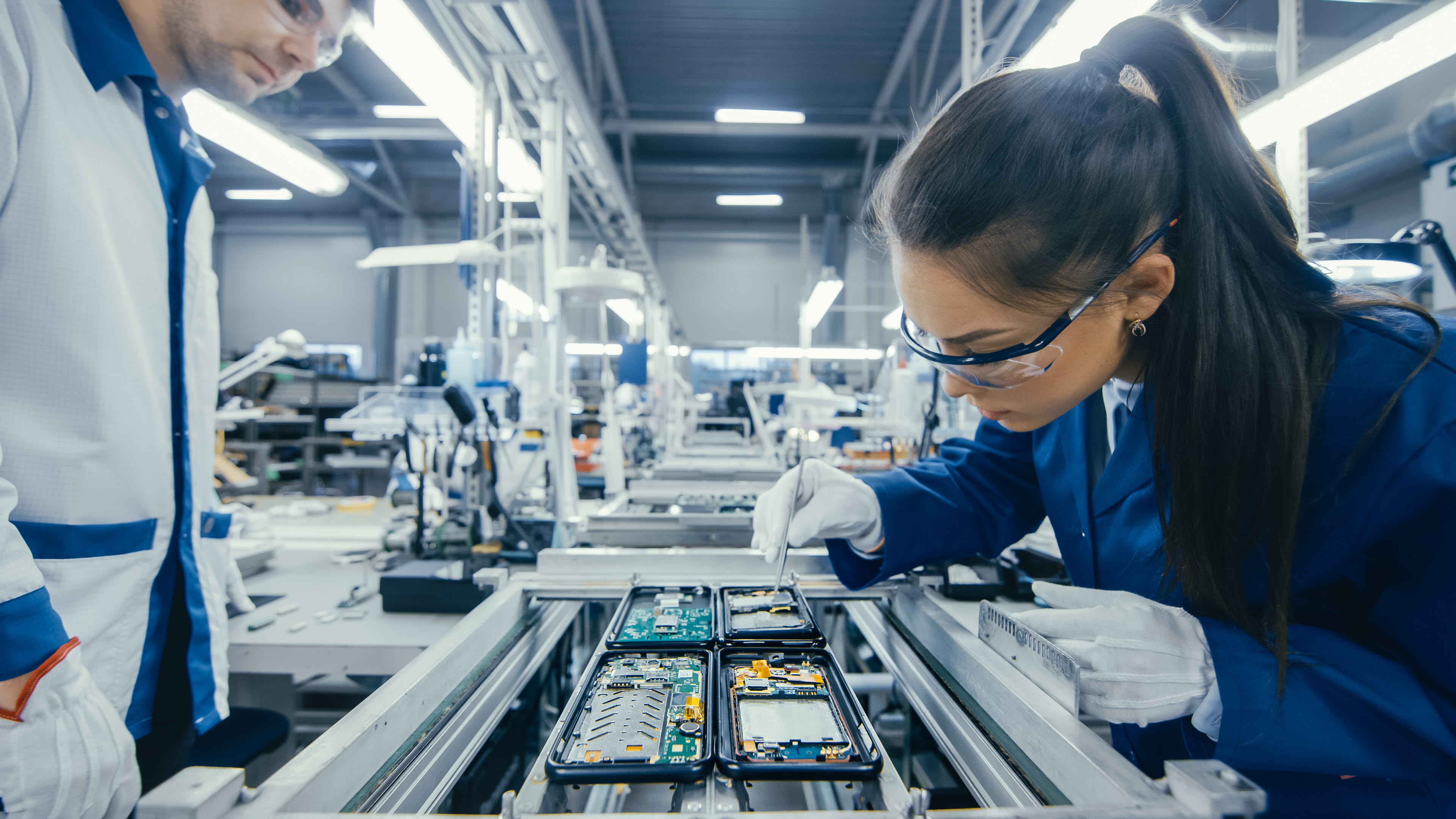 Woman working on mobile phones assembly line